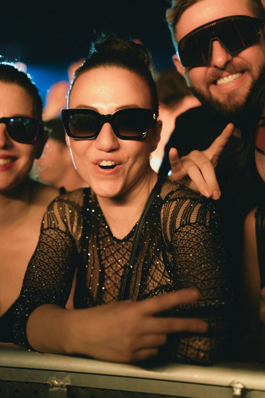 people in sunglasses enjoying themselves at a concert